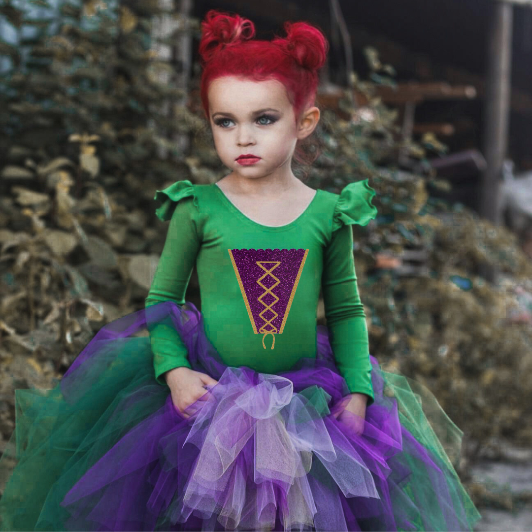 Little girl wearing green ruffle long sleeve leotard with "Winifred" inspired design on front.